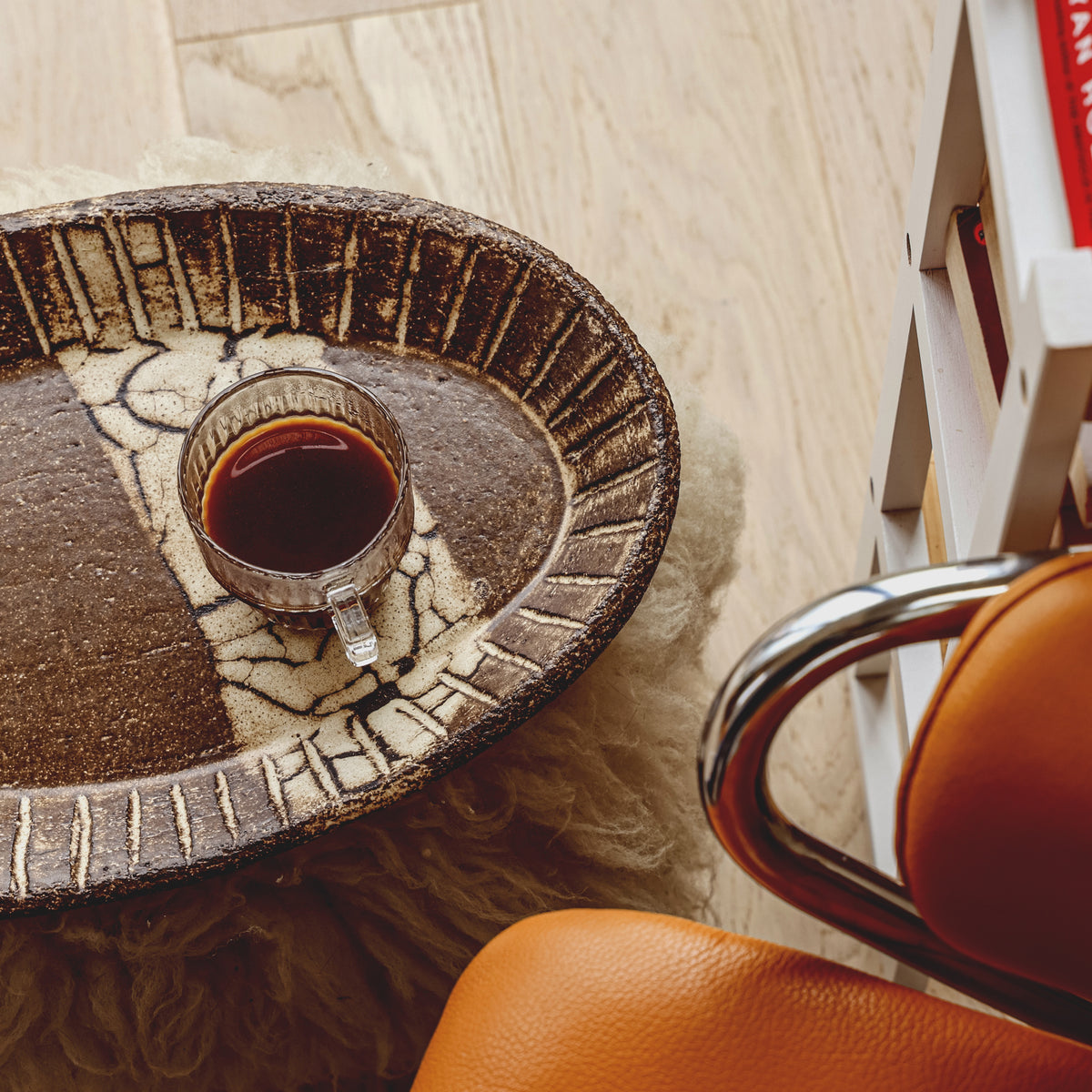 Espresso in a glass cup on a woven tray
