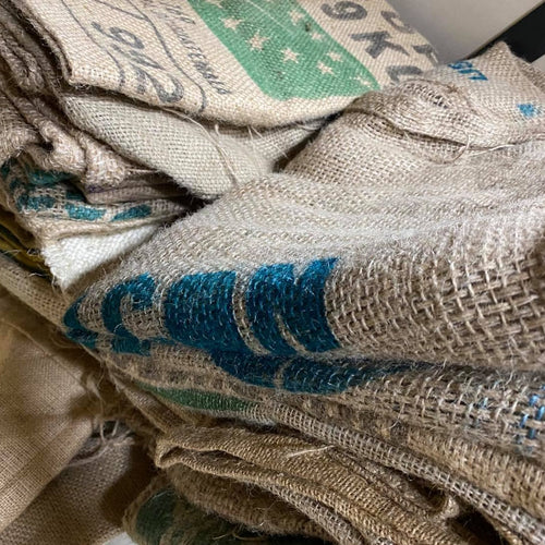 Pile of used hessian coffee sacks with origin prints