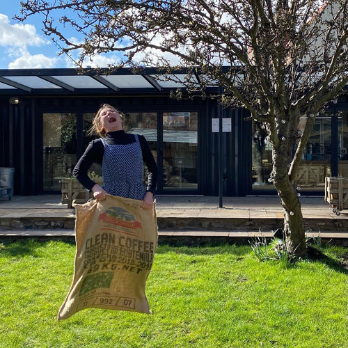 Holding up a used hessian coffee sack in the garden on Holy Island